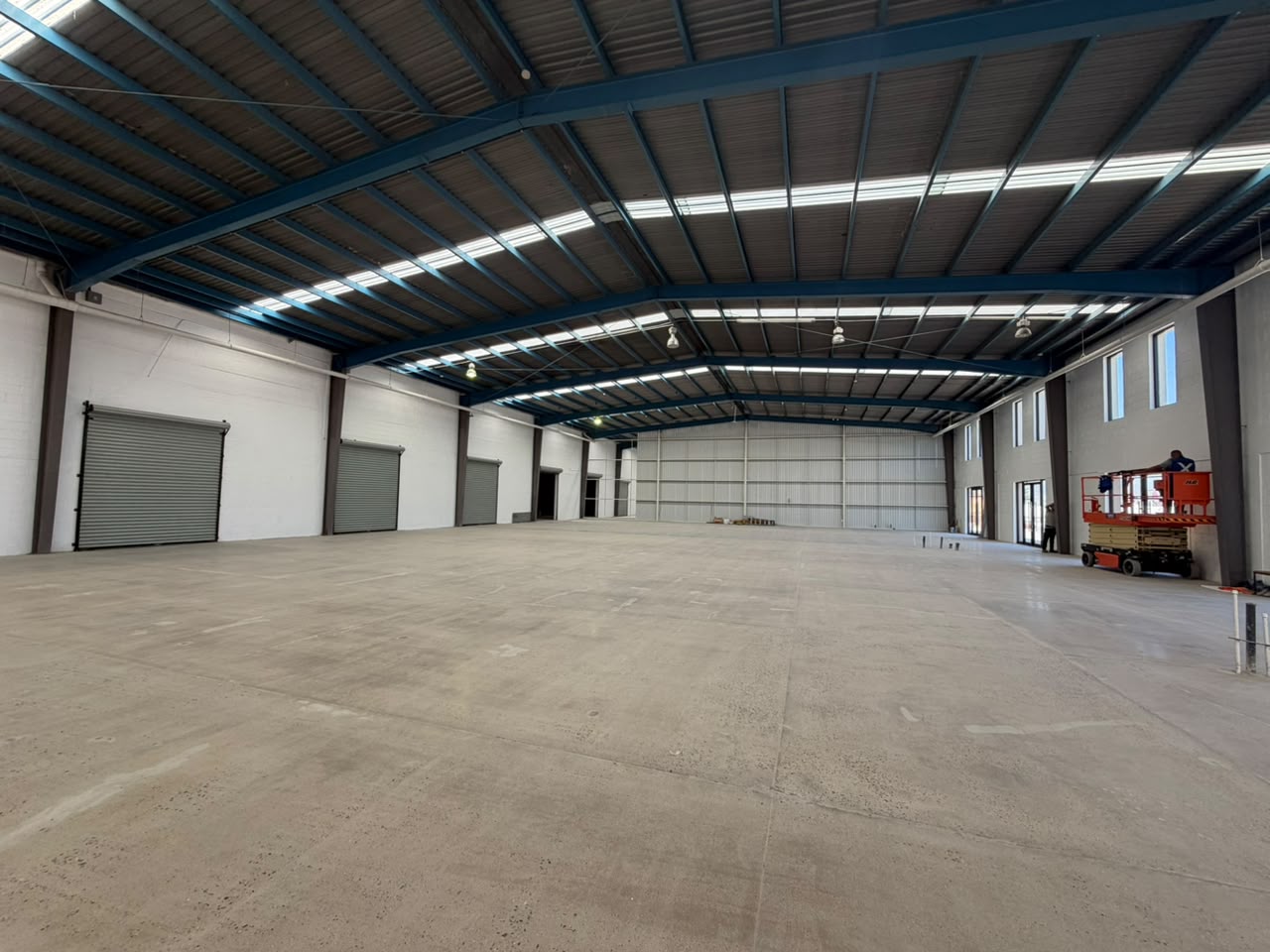 Interior de nave industrial con estructura metálica a dos aguas y tragaluces continuos, Tijuana